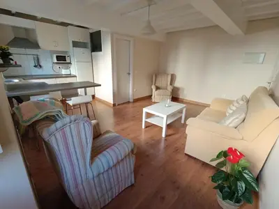 a living room with two couches and a kitchen at Casa Silandeira in Viveiro