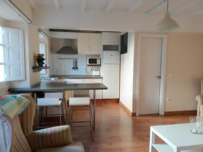 a kitchen and living room with a table and chairs at Casa Silandeira in Viveiro