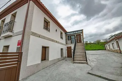 a building with a stairway leading to a door at Apartamentos O Grilo in Doade