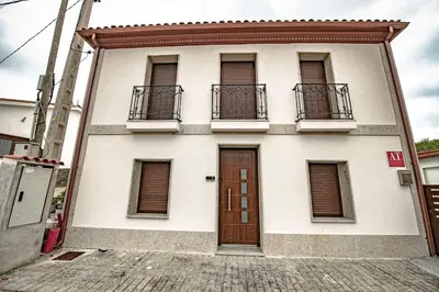 a building with two balconies and a door at Apartamentos O Grilo in Doade