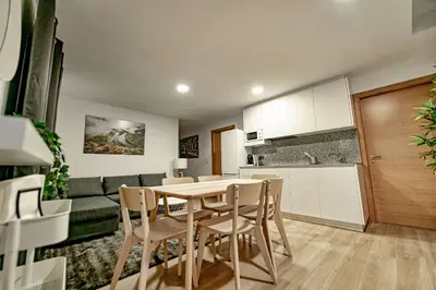 a kitchen and a dining room with a table and chairs at Apartamentos O Grilo in Doade