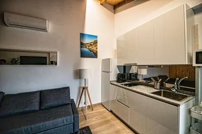 a kitchen and a living room with a couch at Apartamentos O Grilo in Doade