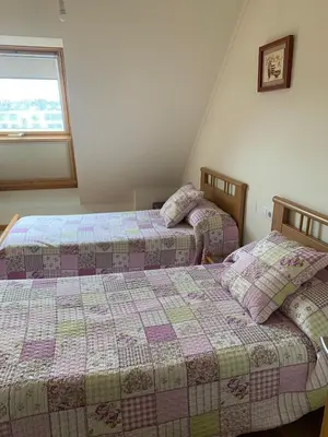 two beds sitting next to each other in a bedroom at Sea, pool, and comfort in a duplex in Foz