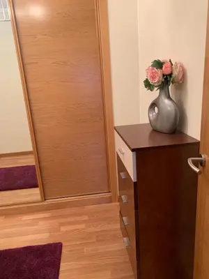 a vase with flowers on a dresser next to a door at Sea, pool, and comfort in a duplex in Foz
