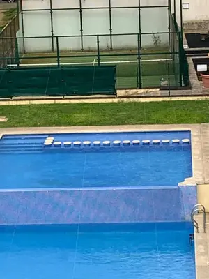 an empty swimming pool with blue water at Sea, pool, and comfort in a duplex in Foz