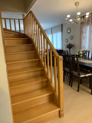 a wooden staircase in a dining room with a dining table at Sea, pool, and comfort in a duplex in Foz