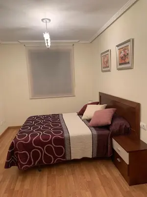 a bedroom with a bed and a table in it at Sea, pool, and comfort in a duplex in Foz