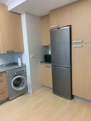 a kitchen with a refrigerator and a washing machine at Sea, pool, and comfort in a duplex in Foz