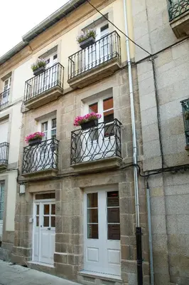 a building with two balconies and flowers on it at Casa Baran in Sarria
