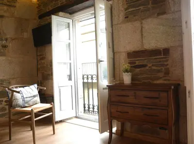 a room with a door and a chair and a dresser at Casa Baran in Sarria