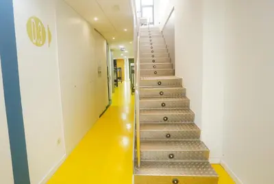 a staircase in a building with a yellow floor at Albergue Spa Cruceiro de Pedrouzo in O Pedrouzo
