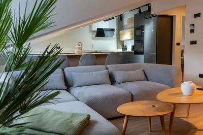 a living room with a couch and a kitchen at APARTAMENTOS SARMIENTO - ÁTICO in Mondoñedo