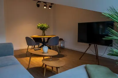 a living room with a table and a tv at APARTAMENTOS SARMIENTO - ÁTICO in Mondoñedo