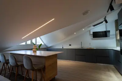 a kitchen with a table and chairs in a room at APARTAMENTOS SARMIENTO - ÁTICO in Mondoñedo