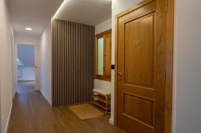 a hallway with a wooden door and a room at APARTAMENTOS SARMIENTO - ÁTICO in Mondoñedo
