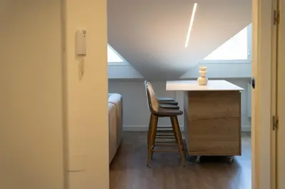 a room with a desk and a chair next to a window at APARTAMENTOS SARMIENTO - ÁTICO in Mondoñedo