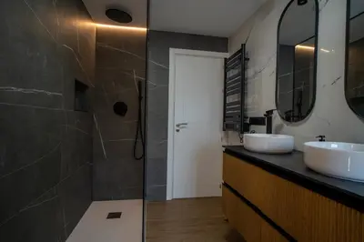 a bathroom with two sinks and a shower at APARTAMENTOS SARMIENTO - ÁTICO in Mondoñedo