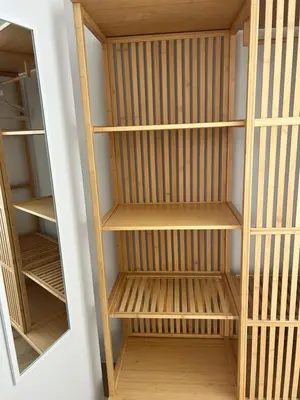 a closet with wooden shelves and a mirror at Pensión do Catro in Puebla de Trives