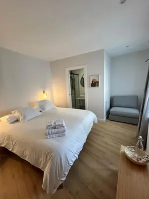 a bedroom with a large white bed and a blue couch at Pensión do Catro in Puebla de Trives