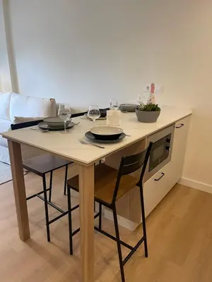 a table with two glasses of wine on it in a kitchen at Apartamento R14 en Miño con 2 dormitorios, salón-cocina, 1 baño y zona de lavandería, situado cerca de las playas in Miño