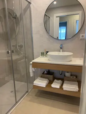 a bathroom with a sink and a shower with a mirror at Apartamento R14 en Miño con 2 dormitorios, salón-cocina, 1 baño y zona de lavandería, situado cerca de las playas in Miño