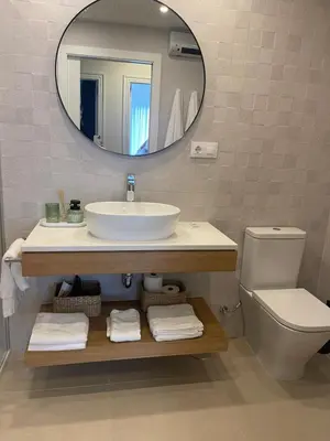 a bathroom with a sink and a mirror and a toilet at Apartamento R14 en Miño con 2 dormitorios, salón-cocina, 1 baño y zona de lavandería, situado cerca de las playas in Miño