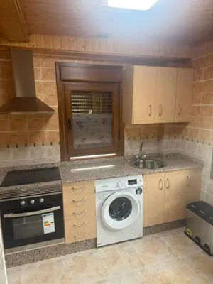 a kitchen with a washing machine and a sink at Casa Divina in Lago de Carucedo