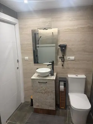 a bathroom with a toilet and a sink and a mirror at Casa Divina in Lago de Carucedo