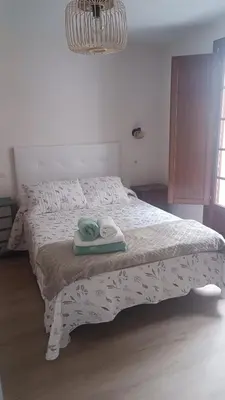 a bedroom with a bed with two towels on it at Apartamento Galería Cine Colón in Ribadeo