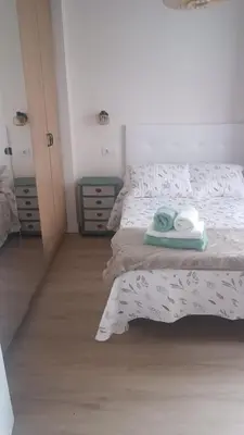 a bedroom with a bed with two towels on it at Apartamento Galería Cine Colón in Ribadeo