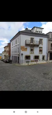 a large white building on the side of a street at Apartamento Galería Cine Colón in Ribadeo