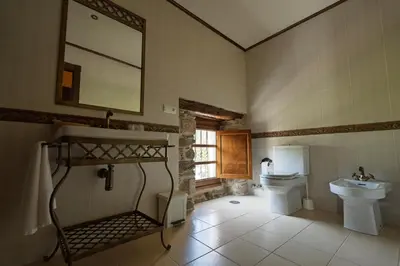 a bathroom with a sink and a toilet and a mirror at Casa Grande Da Torre in Landrove