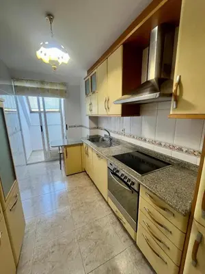 a kitchen with wooden cabinets and a stove top oven at As Marismas - Miño in Miño