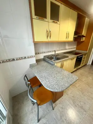 a kitchen with a sink and a table with a chair at As Marismas - Miño in Miño