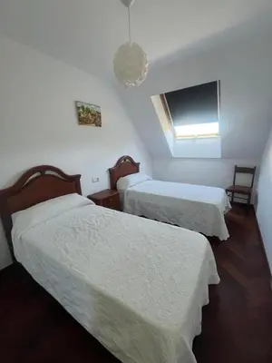 a hotel room with two beds and a television at As Marismas - Miño in Miño
