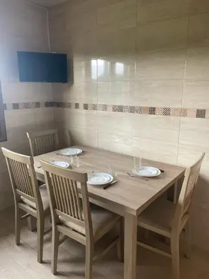 a wooden table with four chairs around it with plates and glasses at Casa do Carpinteiro in Brocos