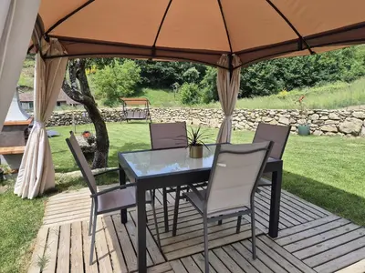 a table and chairs under an umbrella on a deck at Palleira da Aira in Entrambosríos