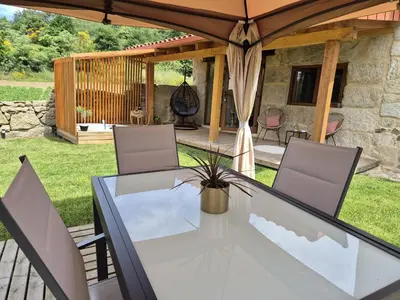 a patio with a table and chairs under an umbrella at Palleira da Aira in Entrambosríos