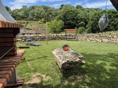 a yard with a stone wall and a playground at Palleira da Aira in Entrambosríos