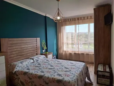 a bedroom with a bed and a large window at El hogar de 2 y 4 patas in Silleda