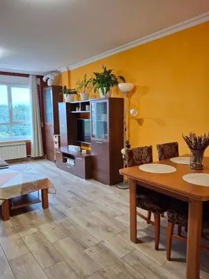 a living room with a table and a yellow wall at El hogar de 2 y 4 patas in Silleda