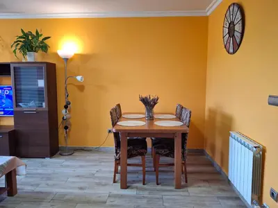 a dining room with a table and chairs and a clock at El hogar de 2 y 4 patas in Silleda