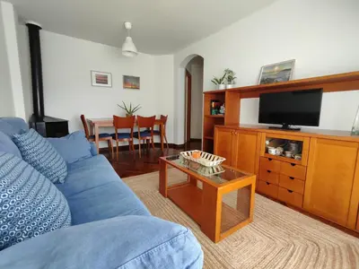 a living room with a blue couch and a tv at Apartamento centro de Sada in Sada