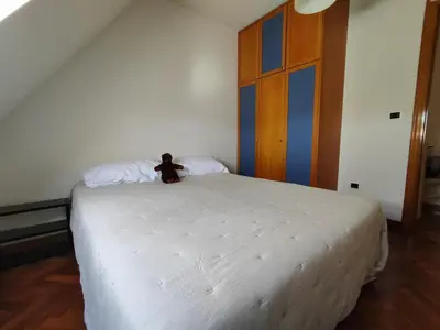 a bed with a teddy bear sitting on top of it at Apartamento centro de Sada in Sada