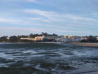 a body of water with a town in the background at Apartamento centro de Sada in Sada
