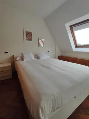 a bedroom with a large white bed with a window at Apartamento centro de Sada in Sada