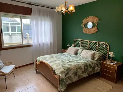 a bedroom with a bed with green walls and a mirror at Apartamento Playa de Foz in Foz