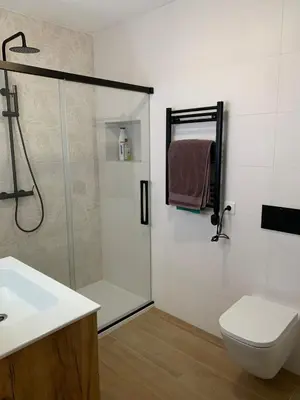 a bathroom with a shower and a toilet and a sink at Apartamento Playa de Foz in Foz