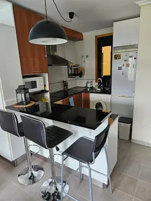 a kitchen with a black counter and chairs in it at Spa Costa Reinante in San Miguel de Reinante