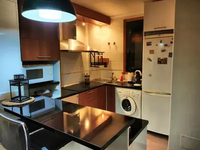 a kitchen with a black counter top and a refrigerator at Spa Costa Reinante in San Miguel de Reinante